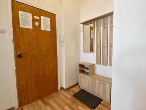 ein Badezimmer mit einer Holztür und einem Spiegel in der Unterkunft Apartment Insat in Stettin