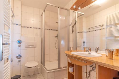 a bathroom with a shower and a sink and a toilet at Ferienwohnung-7-Auszeit-in-der-Villa-Annabelle in Binz