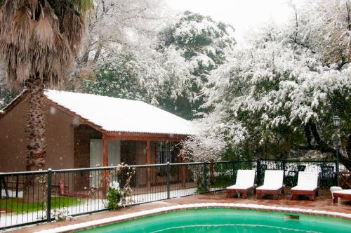 a swimming pool with chairs and snow covered trees at Mont Blanc in Villa General Belgrano
