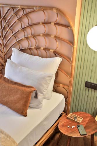 a bed with a wooden headboard and a side table at Luff Boutique Hotel - Adult Only in Kas