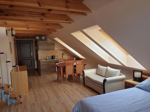 a bedroom with a bed and a dining room with a kitchen at Apartamenty & Restauracja NADMORSKA in Krynica Morska