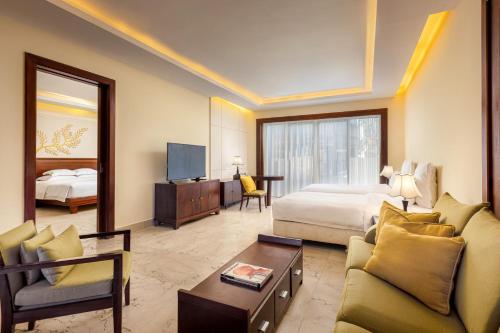 a hotel room with a bed and a living room at Pullman Sanya Yalong Bay Villas & Resort in Sanya
