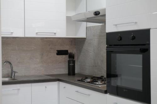 a kitchen with white cabinets and a black refrigerator at Albergo 3 Torri in Maddaloni