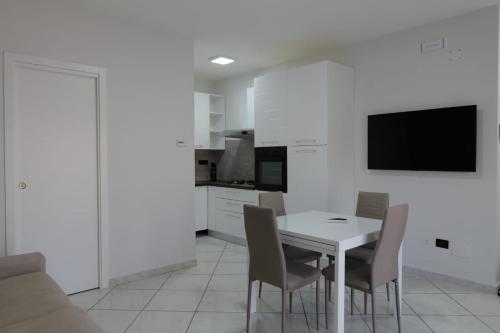 Il comprend une cuisine et une salle à manger avec une table et des chaises blanches. dans l'établissement Albergo 3 Torri, à Maddaloni