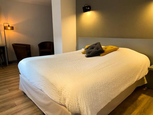 a bed with a stuffed animal on top of it at Logis Hôtel Restaurant Barrey in Orchamps-Vennes