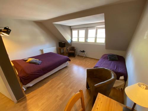 a bedroom with two beds and a table in a room at Logis Hôtel Restaurant Barrey in Orchamps-Vennes