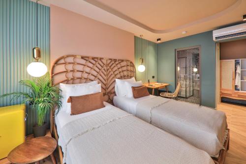 a hotel room with two beds and a table at Luff Boutique Hotel - Adult Only in Kas