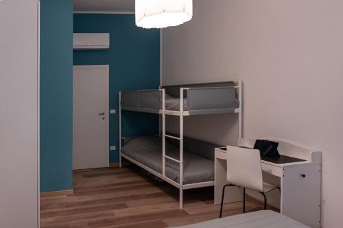a room with a bunk bed with a desk and a chair at Appartamento zio Primo in Castel San Pietro Terme