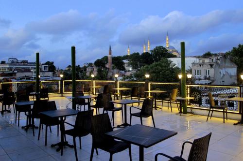 a patio with tables and chairs and a view of the city at Güler Palas Hotel in Istanbul