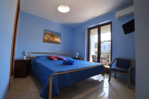a blue bedroom with a bed with blue sheets and a window at B&B PRINCESS ROOM in Capo dʼOrlando
