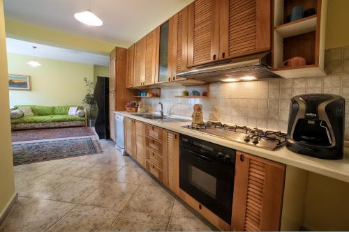 a kitchen with wooden cabinets and a stove top oven at B&B PRINCESS ROOM in Capo dʼOrlando