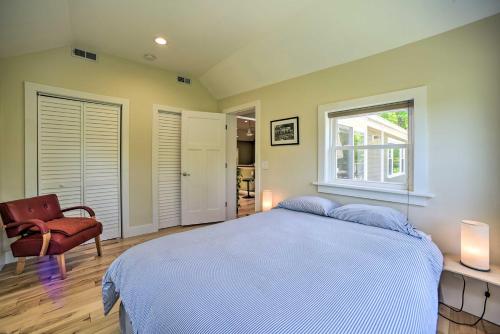 a bedroom with a bed and a window and a chair at Charming Cottage with Deck Mtn and Lake Views! in Wallkill