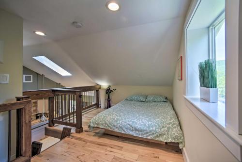 a bedroom with a bed and a staircase with a window at Charming Cottage with Deck Mtn and Lake Views! in Wallkill