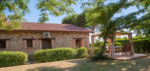 Casa de piedra con mesa y cenador en Finca La Sayuela en El Raso