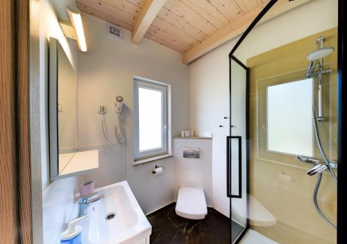 a bathroom with a sink and a shower and a toilet at Apartmenty Magnolia in Łeba