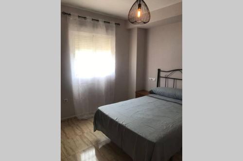 Schlafzimmer mit einem Bett und einem Fenster in der Unterkunft Acogedor apartamento a 5 minutos de la playa in Aguadulce