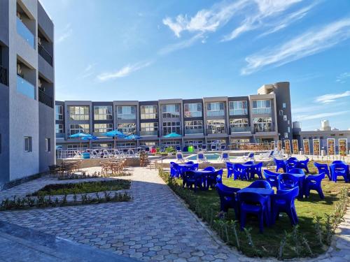 a group of blue chairs and tables in front of a building at Jewel Beach Matrouh Hotel in Marsa Matruh