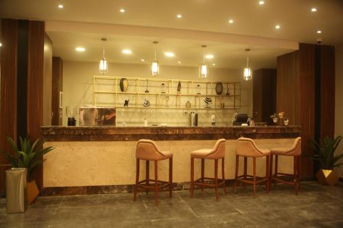 a bar with four stools in front of a counter at Jewel Beach Matrouh Hotel in Marsa Matruh