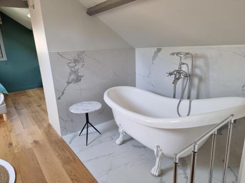 een wit bad in een badkamer met marmeren muren bij Maison Saint Léonard in Honfleur