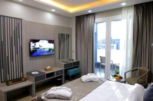 a bedroom with a bed and a desk and a television at Jewel Beach Matrouh Hotel in Marsa Matruh