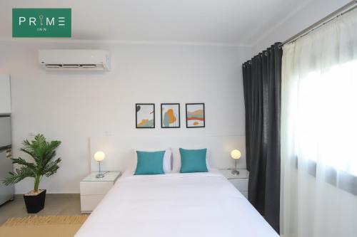 a bedroom with a large white bed with blue pillows at Prime Inn 10th Of Ramadan in Madinat Al Ashir min Ramadan