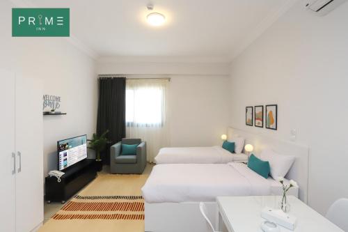 a hotel room with two beds and a tv at Prime Inn 10th Of Ramadan in Madinat Al Ashir min Ramadan