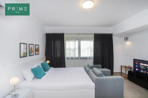 a bedroom with a bed and a couch and a tv at Prime Inn 10th Of Ramadan in Madinat Al Ashir min Ramadan