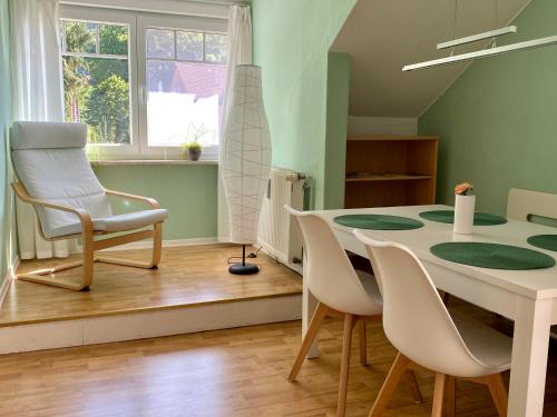 ein Esszimmer mit einem Tisch, Stühlen und einem Fenster in der Unterkunft Apartment Haus Brüchert in Wernigerode