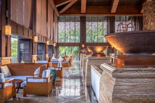 a lobby of a resort with chairs and tables at Pullman Sanya Yalong Bay Villas & Resort in Sanya