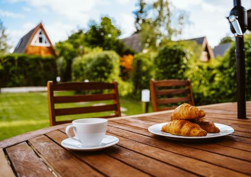 a table with two plates of croissants and a cup of coffee at Nurdachhaus Marie im Nordschwarzwald in Neuhausen