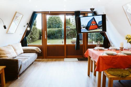 a living room with a couch and a tv at Nurdachhaus Marie im Nordschwarzwald in Neuhausen