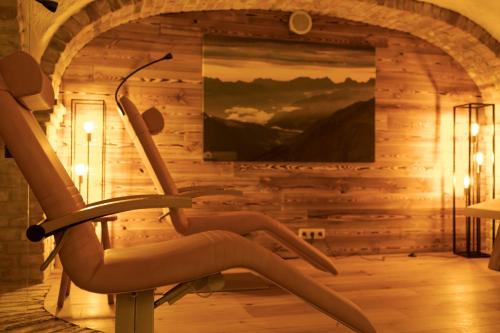 a rocking chair in a room with a painting at Hotel St. Georg in Zell am See