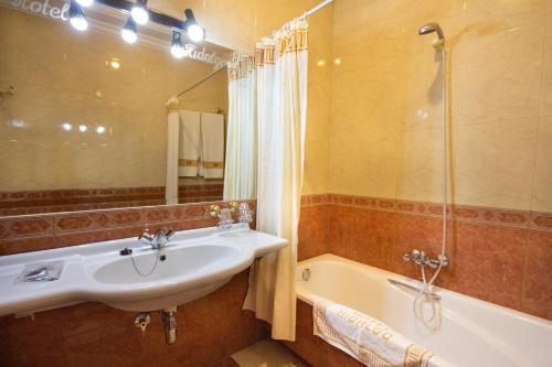 y baño con lavabo y bañera. en Hotel Hidalgo, en Martos