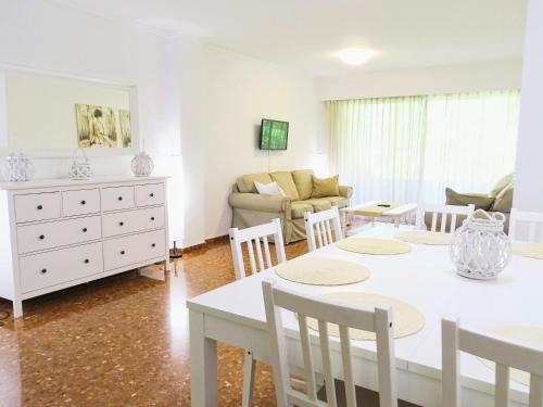 ein Wohnzimmer mit einem weißen Tisch und Stühlen in der Unterkunft Apartamento Tibi - centro de Gandia in Gandía