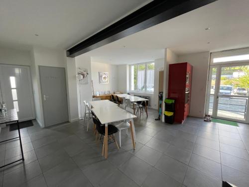 a dining room with a table and a red refrigerator at O' li douillet in Les Épesses