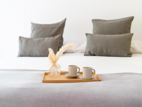 zwei Kaffeetassen und ein Tablett auf dem Bett in der Unterkunft Confortable estudio en medina garden ref 332 in Marbella