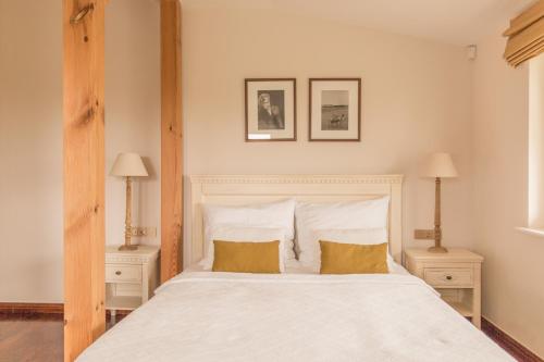 sypialnia z dużym białym łóżkiem z 2 stolikami nocnymi w obiekcie Villa Modiva w mieście Międzyzdroje
