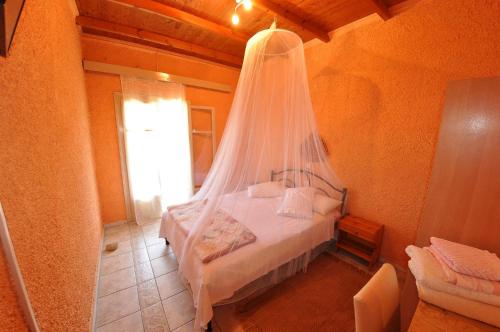 a bedroom with a bed with a mosquito net at Byronas Apartments in Paleokastritsa
