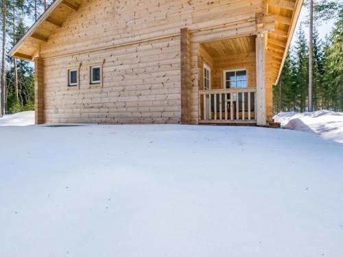 una cabaña de madera con nieve delante en Holiday Home Kaitaranta by Interhome en Kyyrö