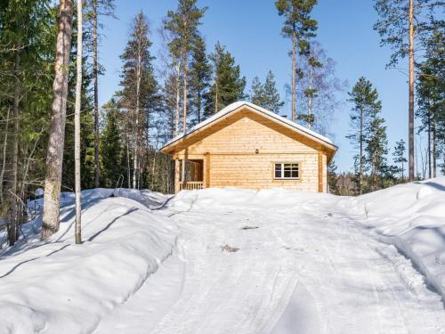 una cabaña de madera en el bosque en la nieve en Holiday Home Kaitaranta by Interhome en Kyyrö
