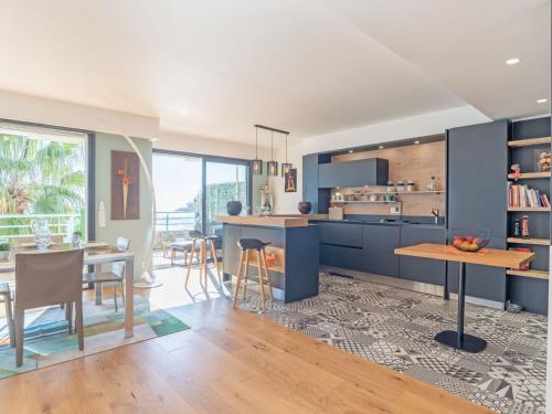 een keuken en eetkamer met blauwe kasten en een tafel bij Apartment New Beach by Interhome in Roquebrune-Cap-Martin