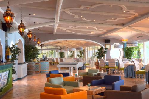 un ristorante con divani, tavoli e sedie di Sorriso Thermae Resort & Spa a Ischia