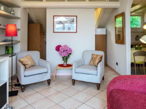 um quarto com duas cadeiras e um vaso de flores em Apartment del Sole-7 by Interhome em Luino