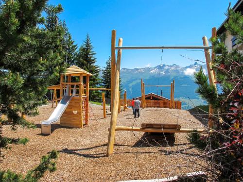 a playground with a slide and a swing at Studio Le Hameau D002 by Interhome in Les Collons