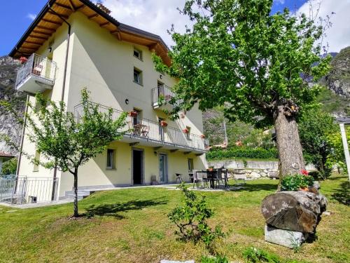 a large yellow house with a tree in the yard at Apartment Gruf by Interhome in Riva