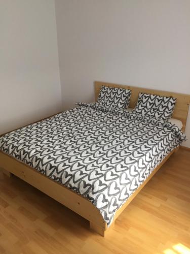 a bed with a black and white comforter and pillows at Vila Maria in Buzau