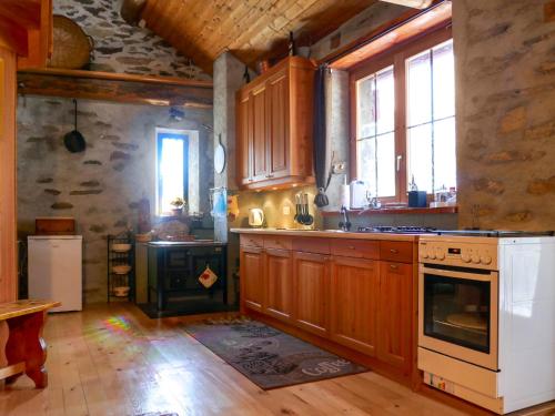 a kitchen with wooden cabinets and a white stove top oven at Holiday Home Rustico Tecc Berbis by Interhome in Castro