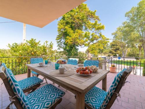 drewniany stół z krzesłami i owocami na patio w obiekcie Villa Can Jeroni by Interhome w Alcudii