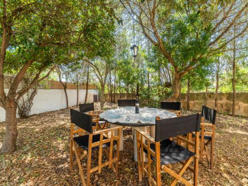 stół i krzesła na dziedzińcu z drzewami w obiekcie Villa Can Jeroni by Interhome w Alcudii