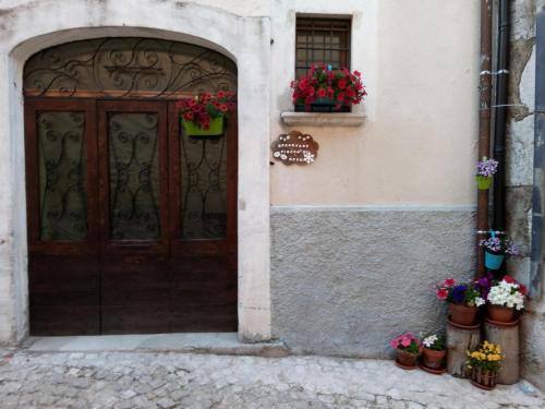 an entrance to a building with a wooden door and flowers at B&B Fiocco di Neve in Rocca di Mezzo